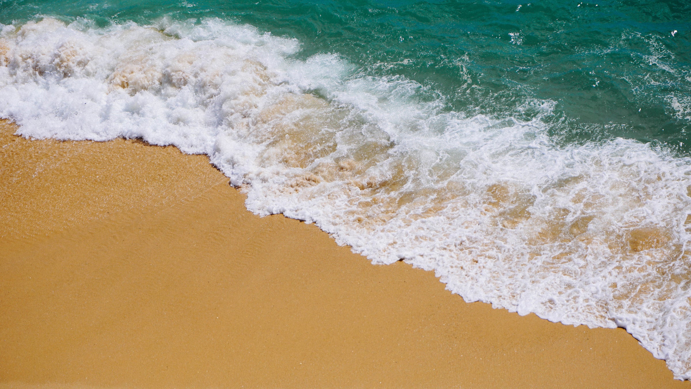 Ein Strandbild von einer sich brechenden Welle - das ist Urlaubsfeeling! Auch die hohen Temperaturen am Strand können deiner noLimit dank der KeepDGREE-Technologie nichts anhaben!